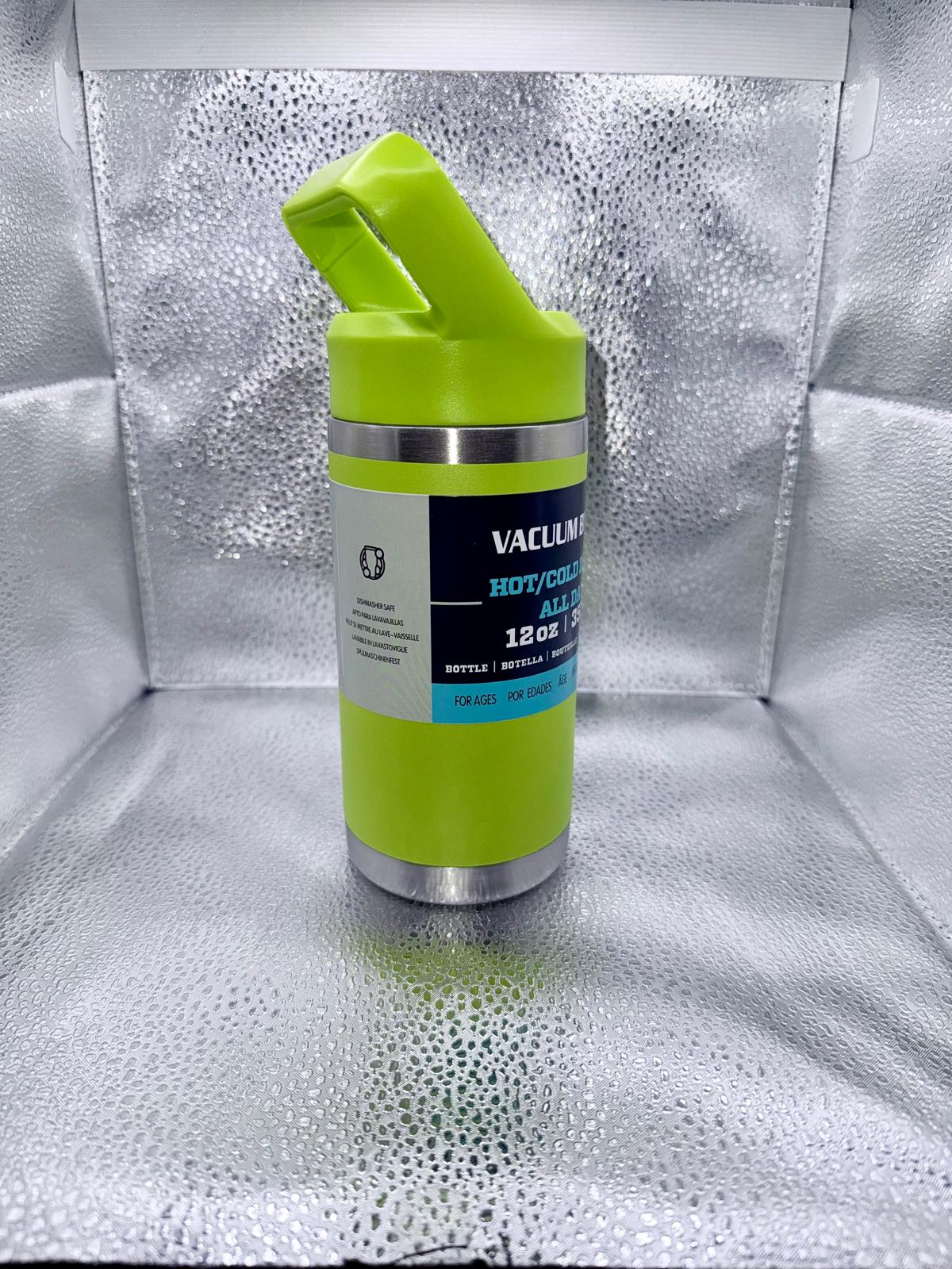Vacuum insulated bottle with green lid and silver body on a reflective surface