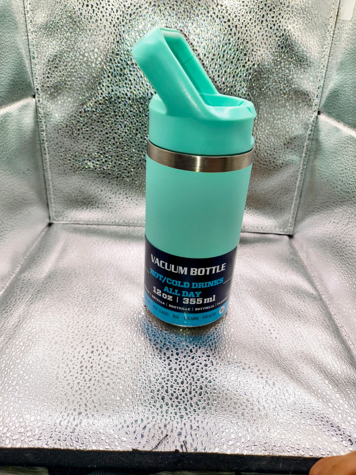 Turquoise vacuum bottle on a metallic surface
